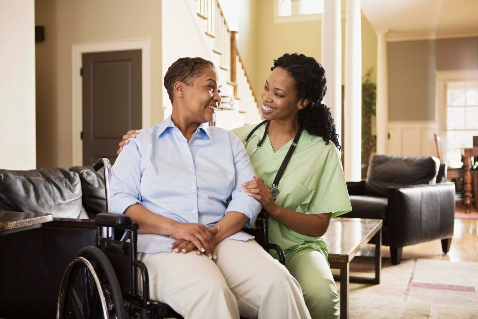 Nurse and Patient in a wheelchair smile at each other